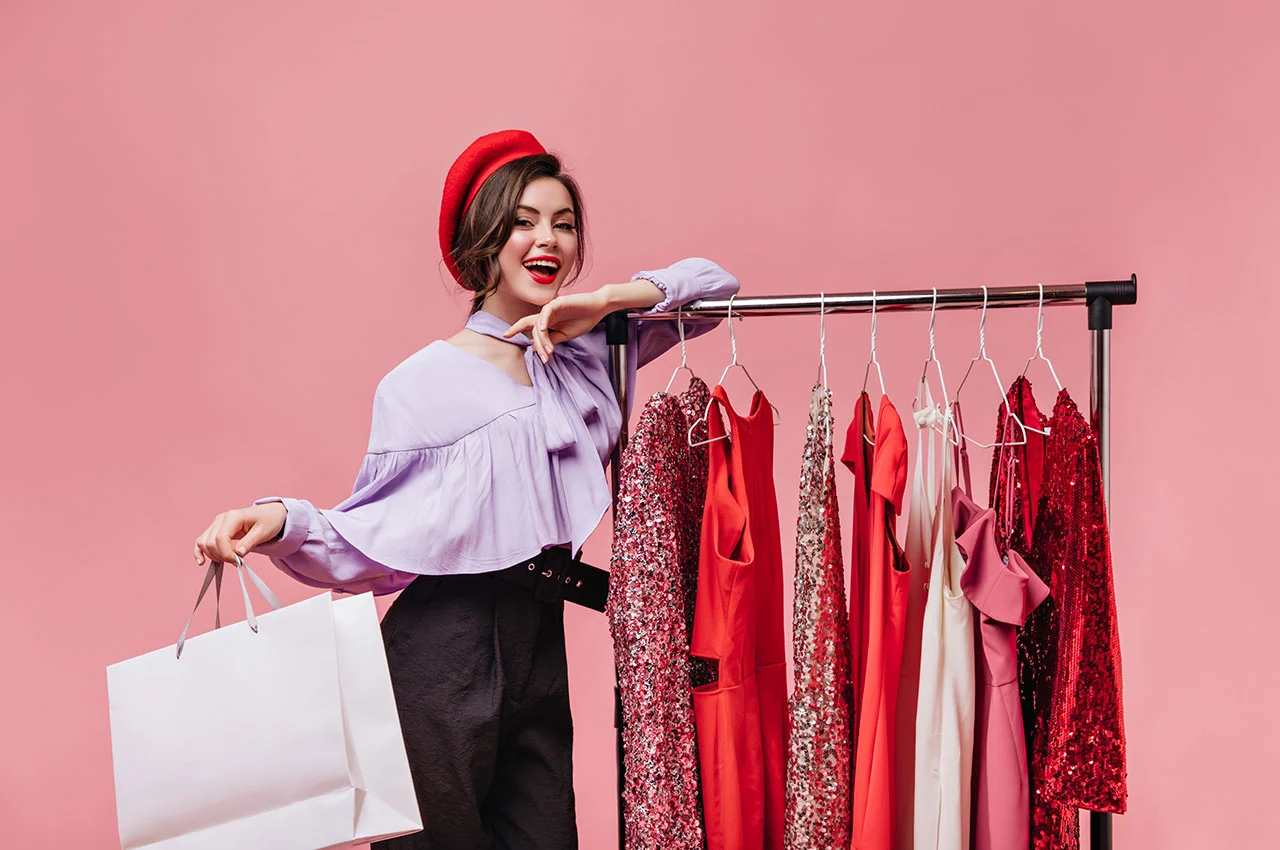 Smiling woman shopping by red dress rack