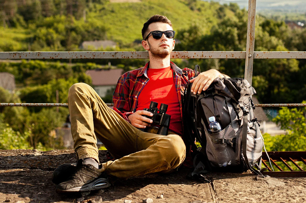 Hiker resting with backpack and binoculars